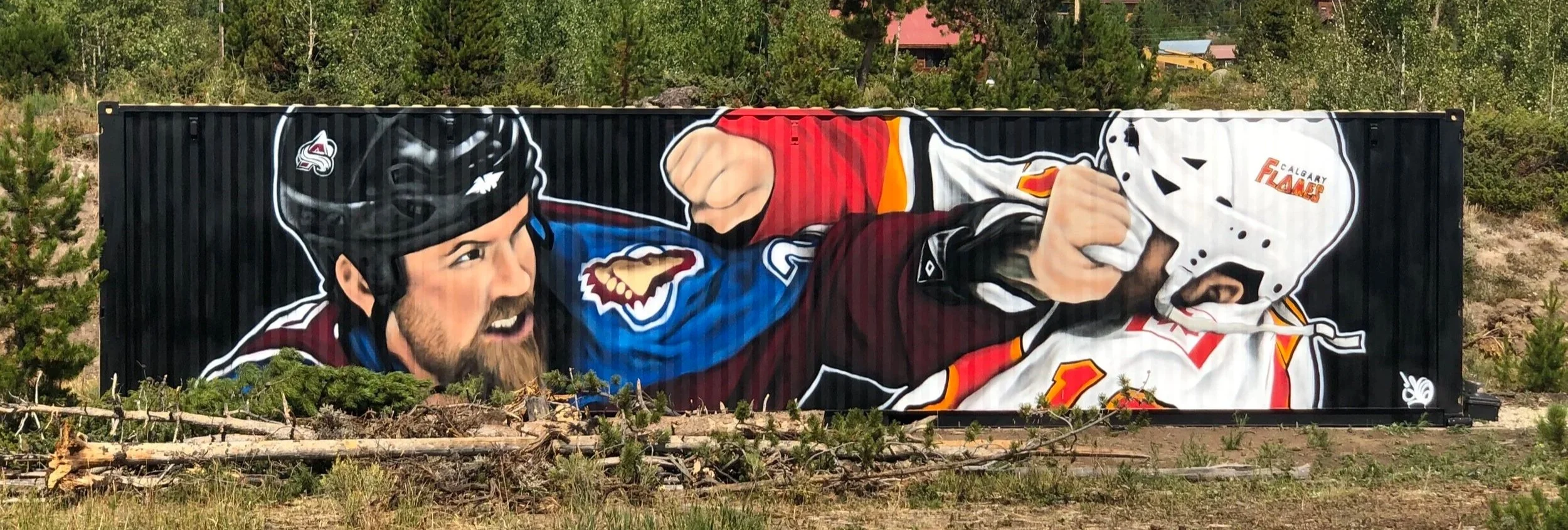 Large mural on a black shipping container depicting a hockey fight. A bearded man in a blue and maroon Colorado Avalanche jersey punches an opposing player in a white Calgary Flames jersey. The Denver Nuggets logo is visible on the bearded man's helm