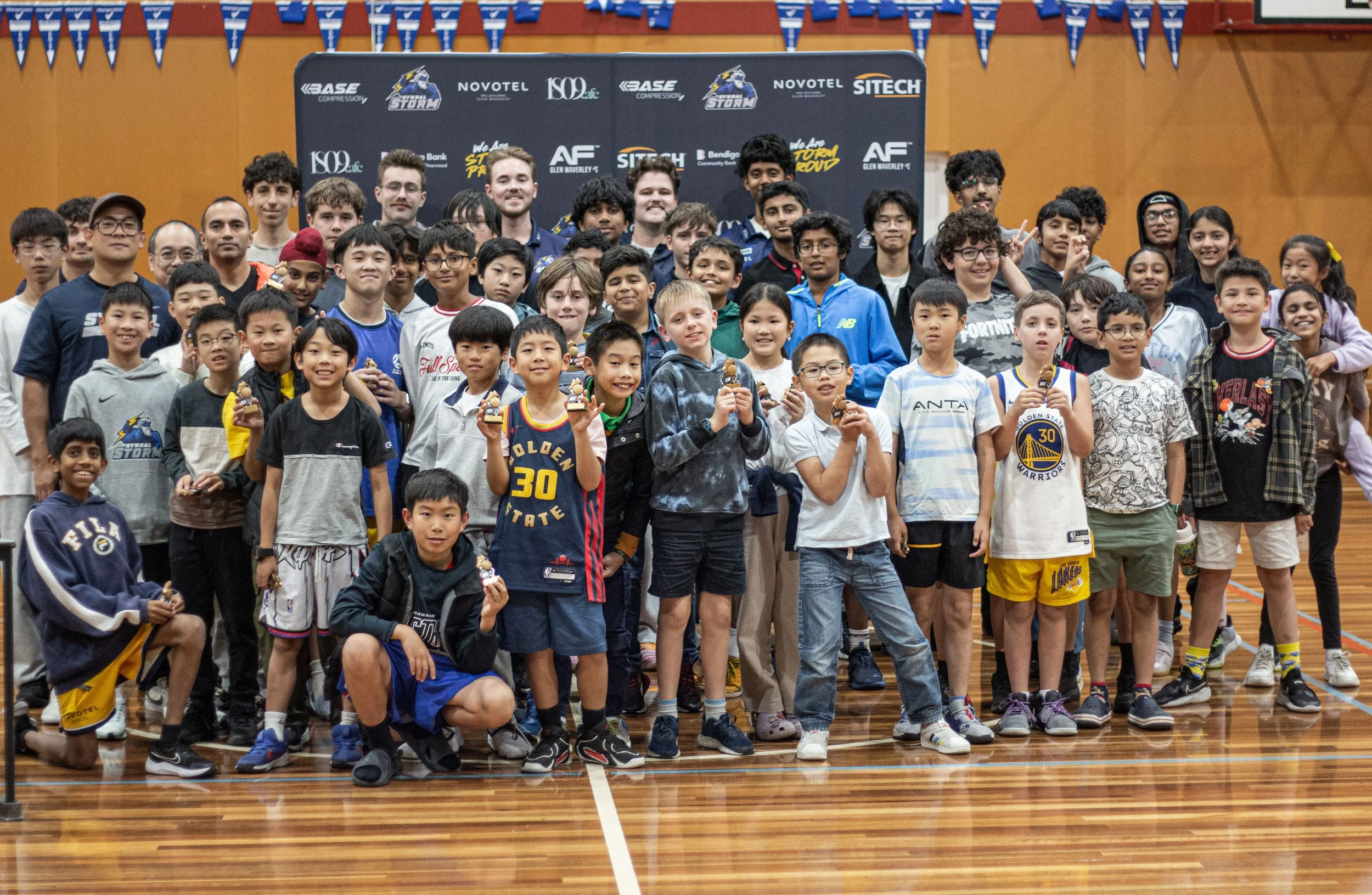 Syndal Storm players and coaches gathered on court with their trophies
