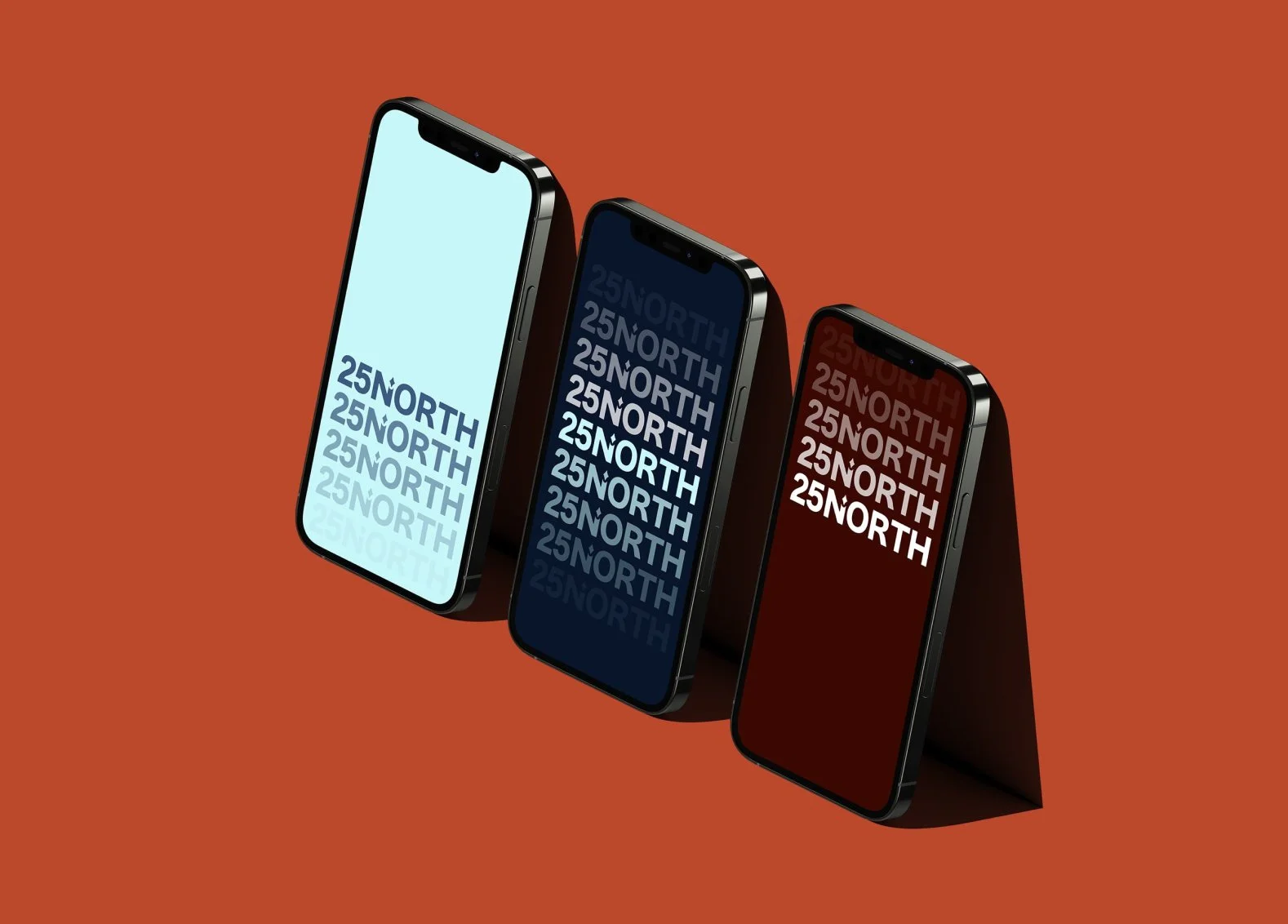 Three smartphones with the text '25 NORTH' displayed on their screens, positioned on a reddish-brown background.