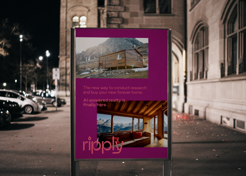 A city street at night with parked cars and an illuminated sign advertising real estate with mountain views.