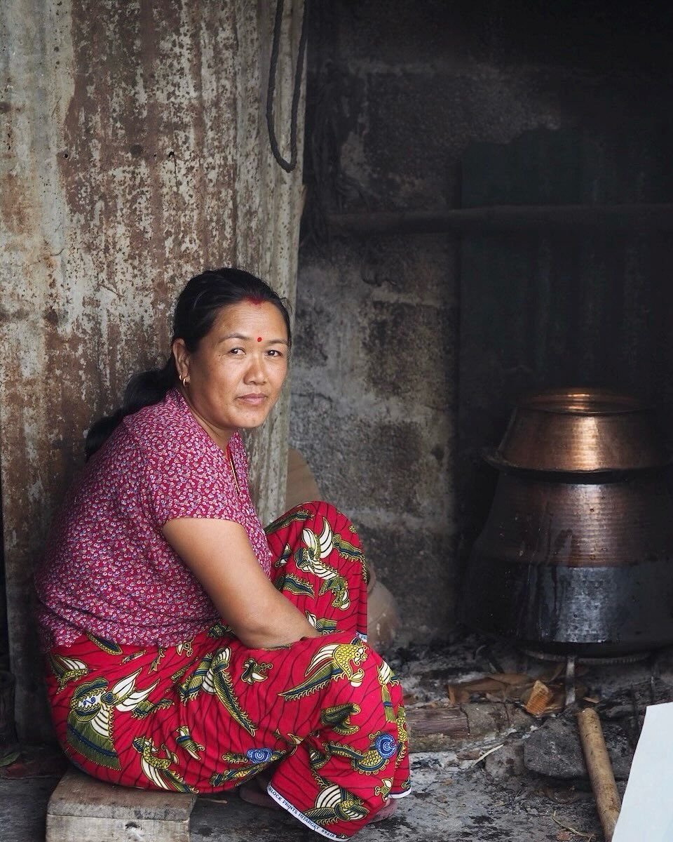 In a small Nepalese village last month, I spent two days with Buddhimaya and her family through @communityhomestaynetwork - milking the buffalo in the morning, threading flower malas, cooking food over an open fire, tending to the land. No machines, 