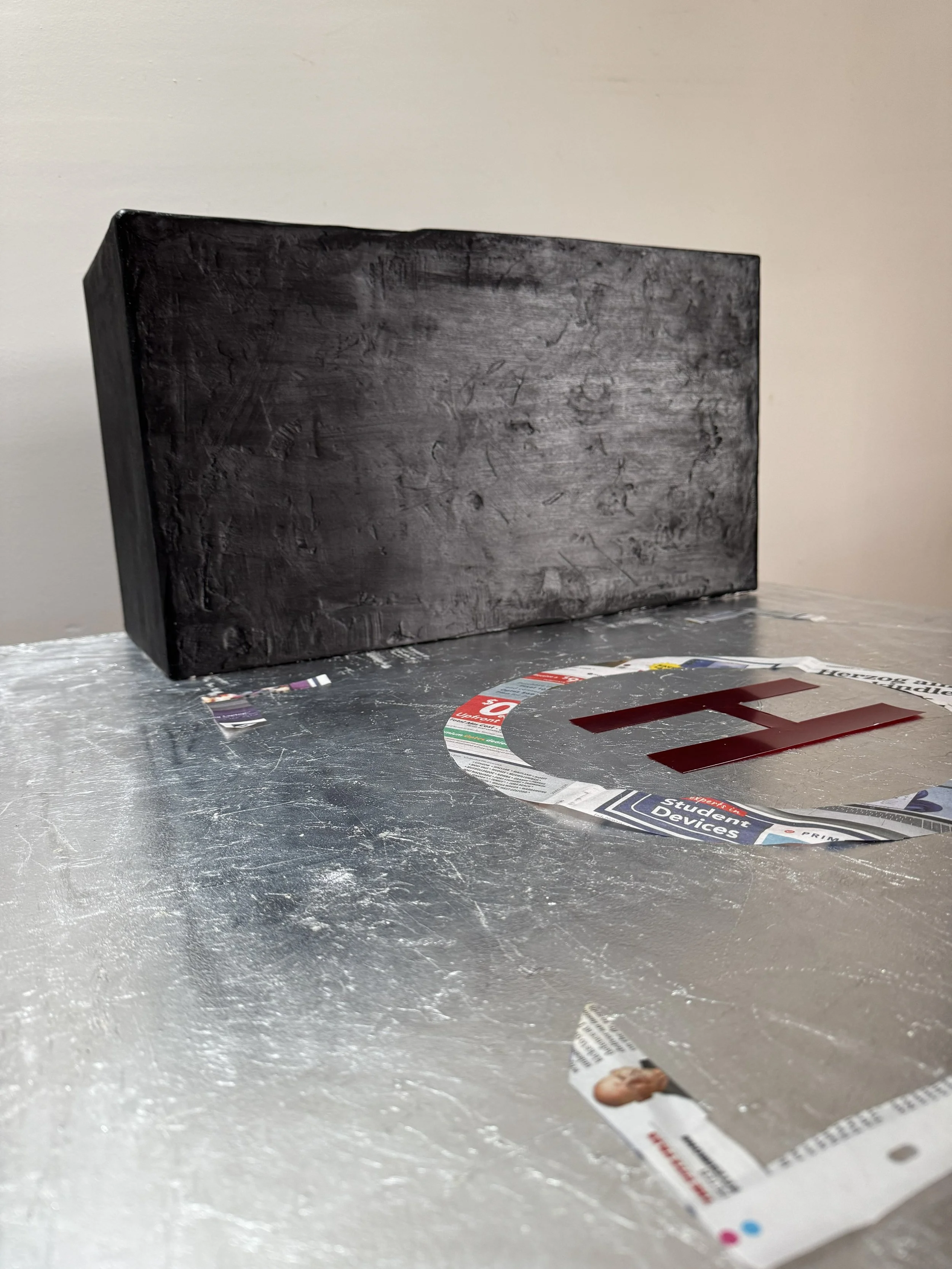 helicopter landing sign made of waste paper with rough black plaster wall is far distance