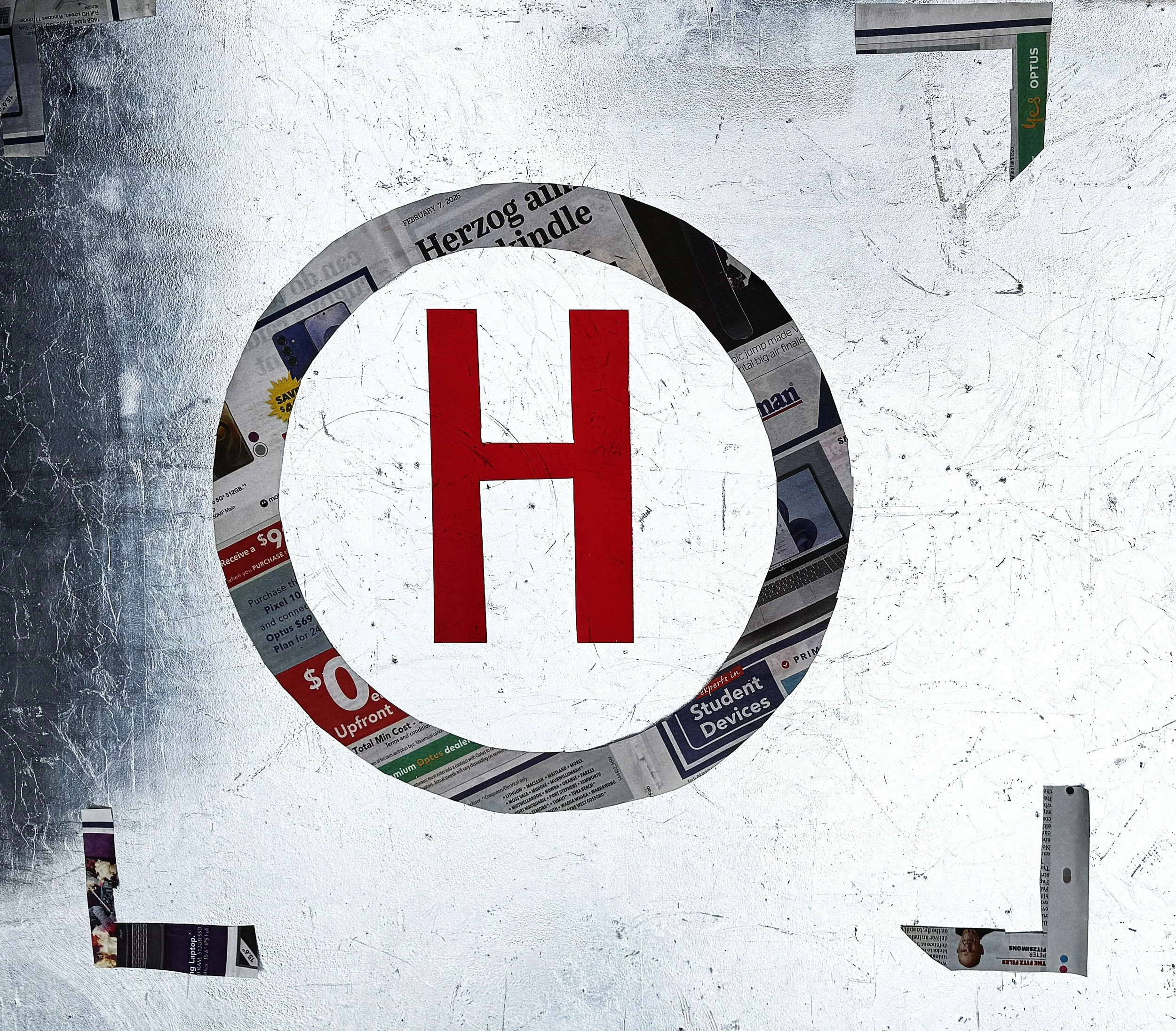 view looking down onto table top to gilded metal background overlaid with helicopter landing symbol