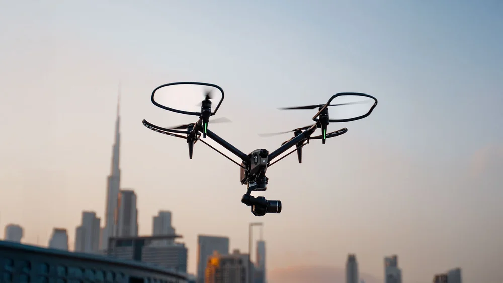 Drone with a cinema camera hovering in front of the Dubai skyline and Burj Khalifa at sunset