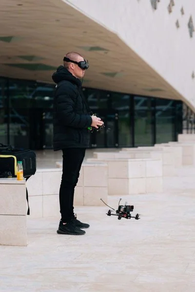 FPV pilot in goggles flying a small FPV drone at KAFD in Riyadh