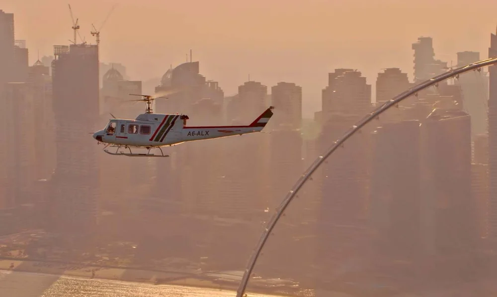 Bell 212 helicopter filmed air-to-air over Dubai Marina in the haze, from our camera helicopter with a Shotover F1