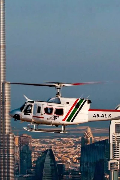 Bell 212 helicopter flying beside the Burj Khalifa in Downtown Dubai