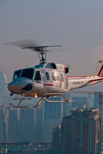 Bell 212 helicopter in flight over the Dubai skyline