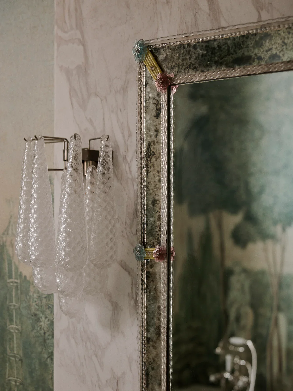 Art deco wall mirror with small, colourful flower-shaped details.  1970s textured glass wall sconce. Tamsin Johnson.