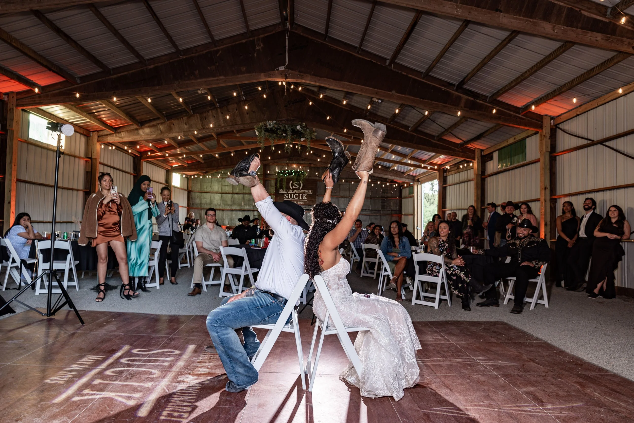 Couple playing shoe game at backyard barn wedding