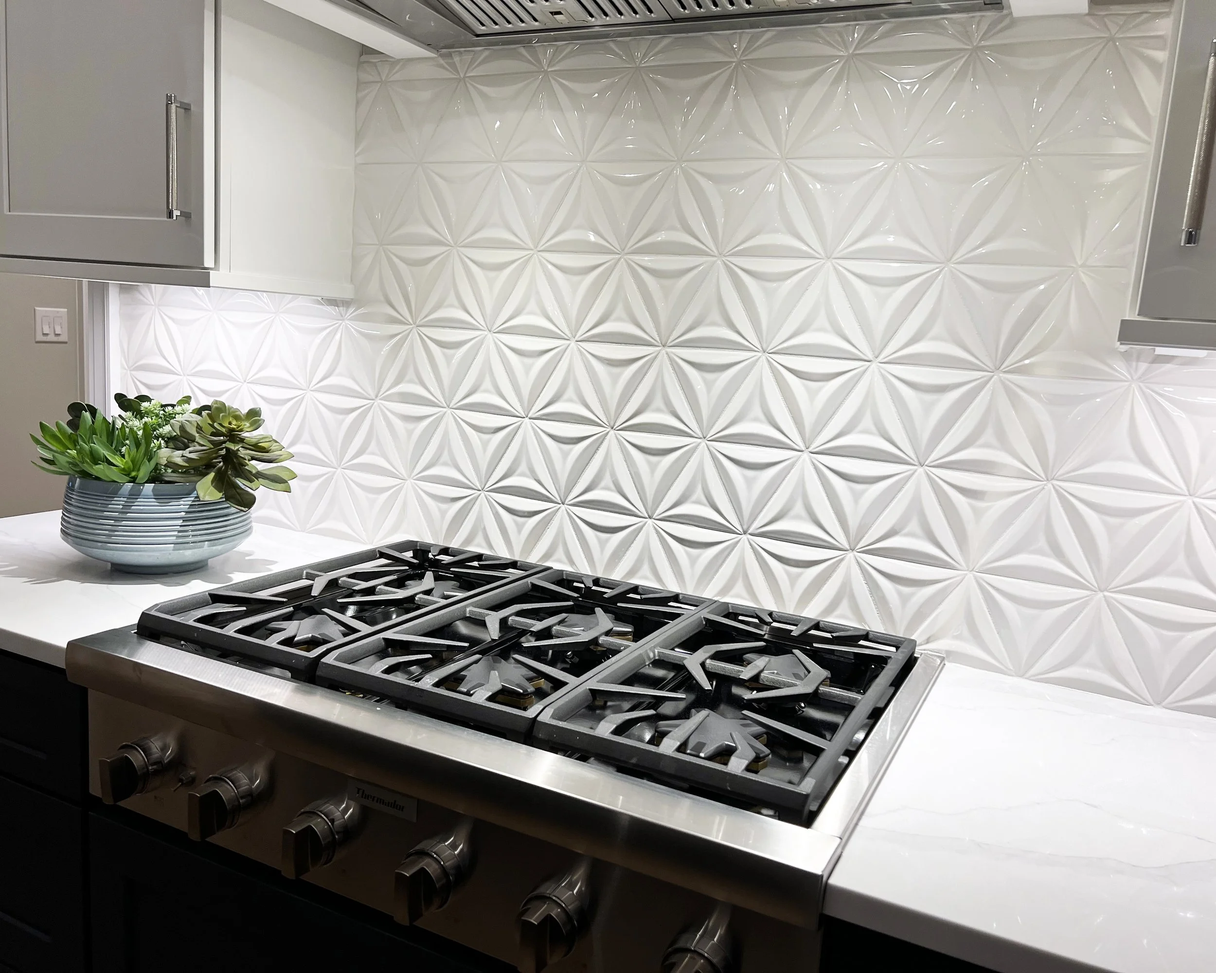 The unique backsplash is uninterrupted by outlets due to plug mold under upper cabinets.