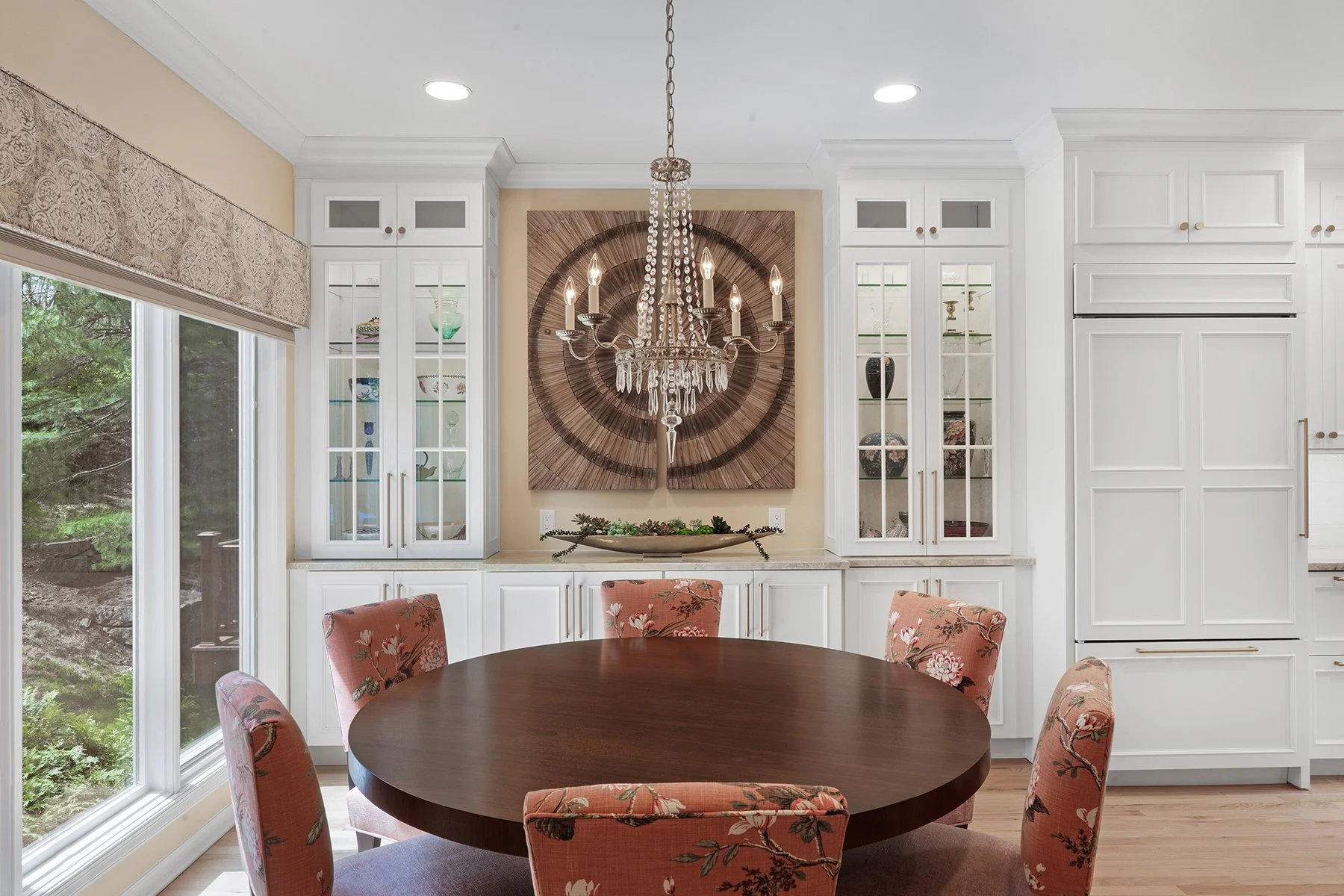 The built-in white cabinetry seemlessly extends from the kitchen into the dining room. Custom artwork was selected as a focal point for the dining space 
