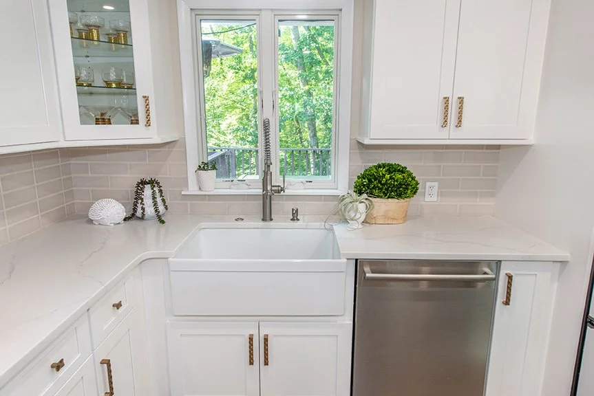The sink, which previously faced the corner, was replaced with a larger farmhouse sink and located more symmetrically under a new casement window.