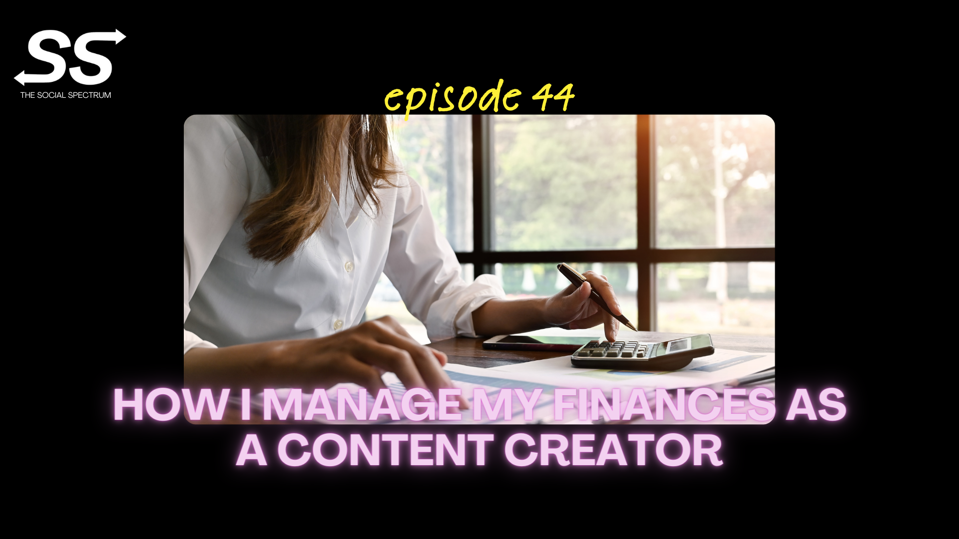 A woman sitting at her desk with a calculator in front of her and papers scattered on the desk