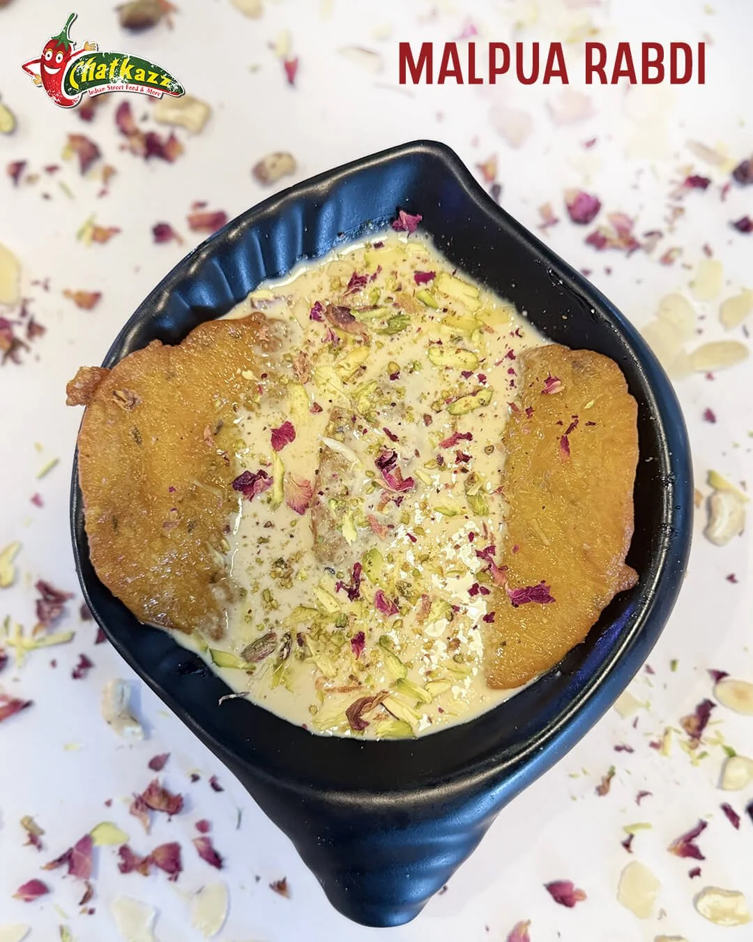 a black bowl containing malpuan and rabri and Indian dish offered at Chatkazz for Holi
