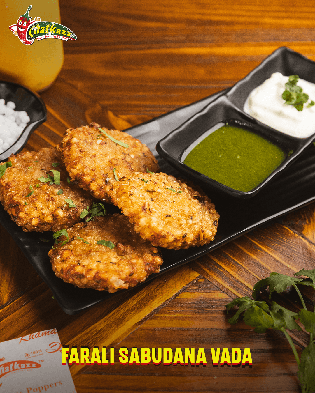 Farali Sabudana Vada served on a black platter with green chutney and yogurt dip at Chatkazz.