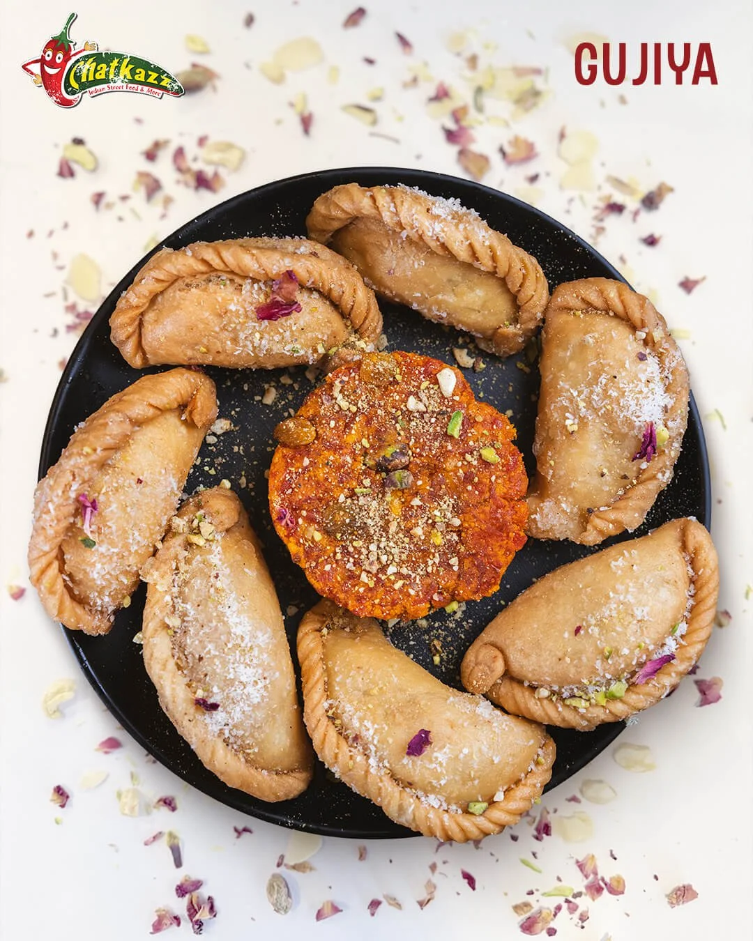 a black plate has Indian dish gujiya and a Chatkazz logo