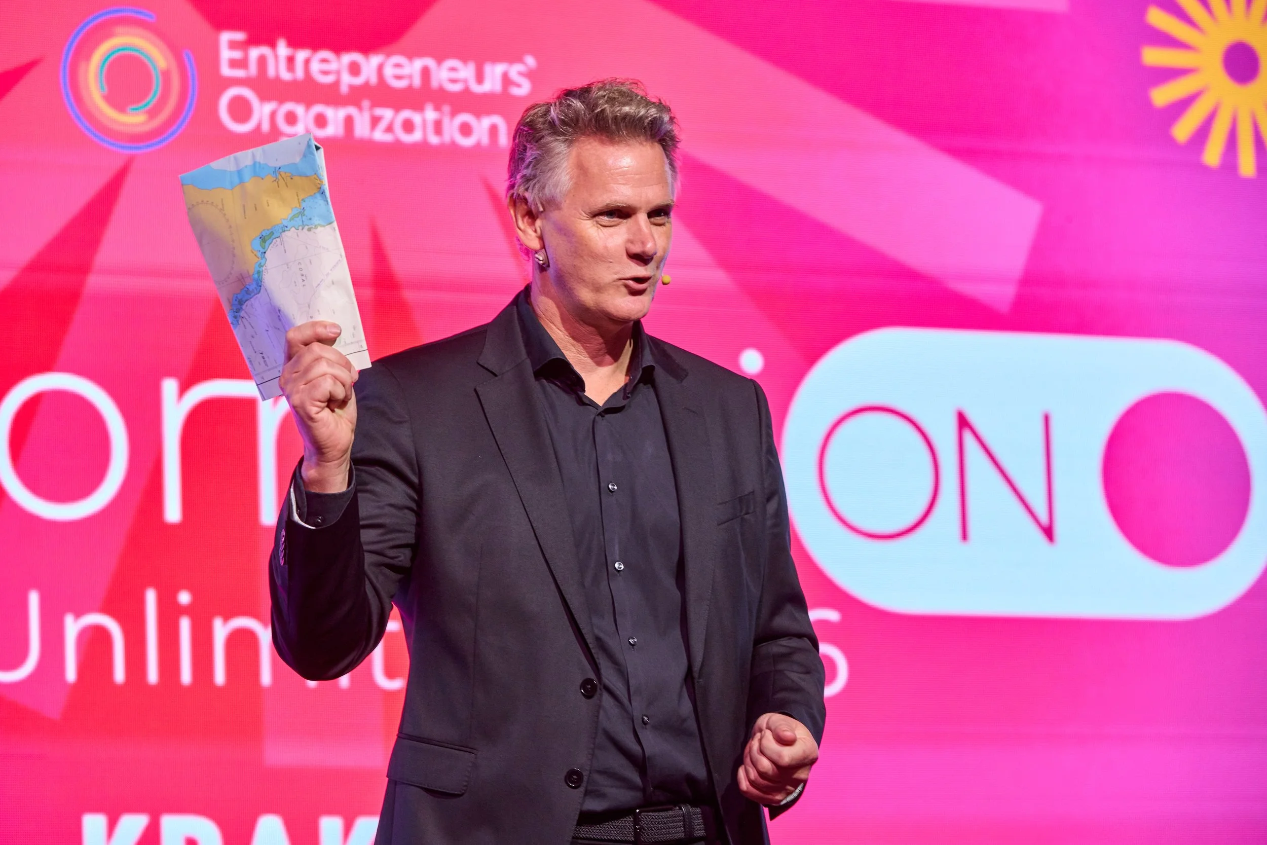 Change management speaker Caspar Craven holding up a set of sea charts: you can't navigate a new world using an old set of charts
