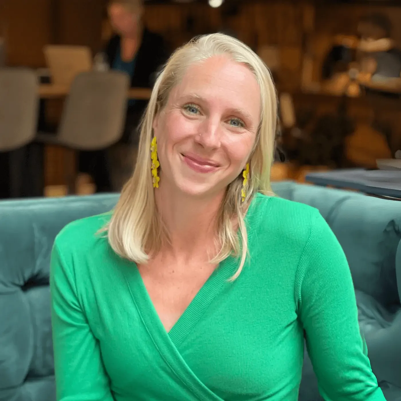 Frida Rångtell, sömnexpert, sitter i en varm och avslappnad miljö och ler mot kameran – fokus på hälsa, återhämtning och välmående i arbetslivet