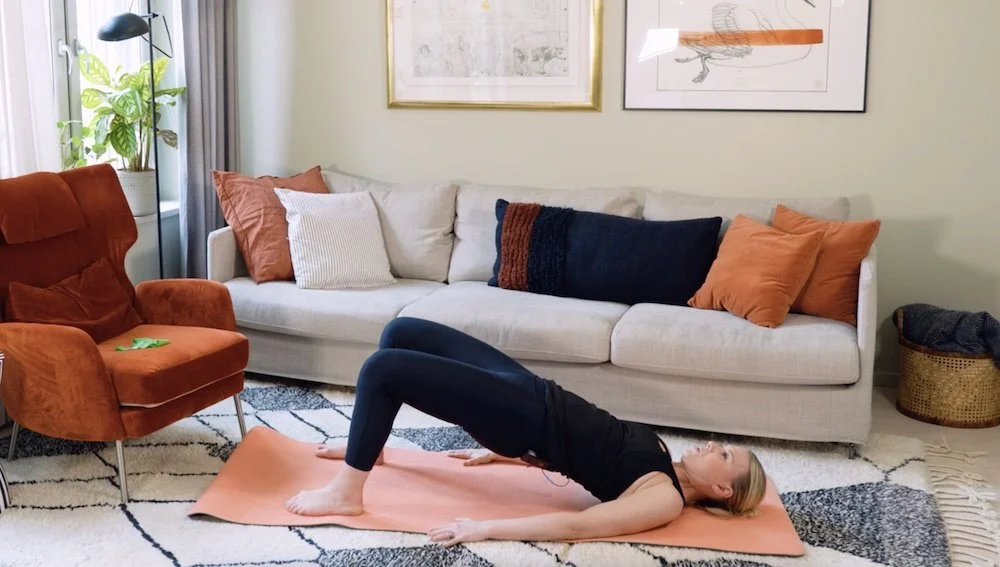 Kvinna som tränar efter förlossning. Övning höftlyft..