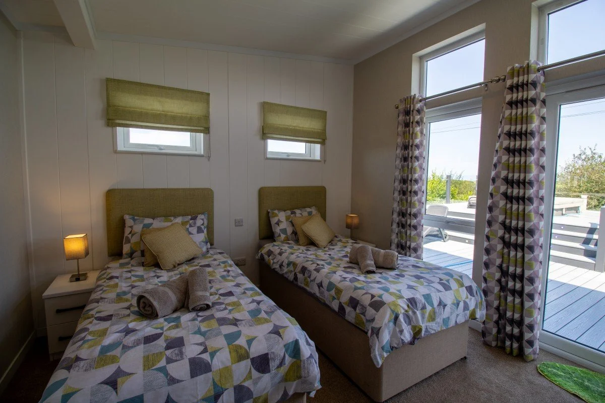 Twin bedroom with two full-size single beds and direct access to the decking and hot tub