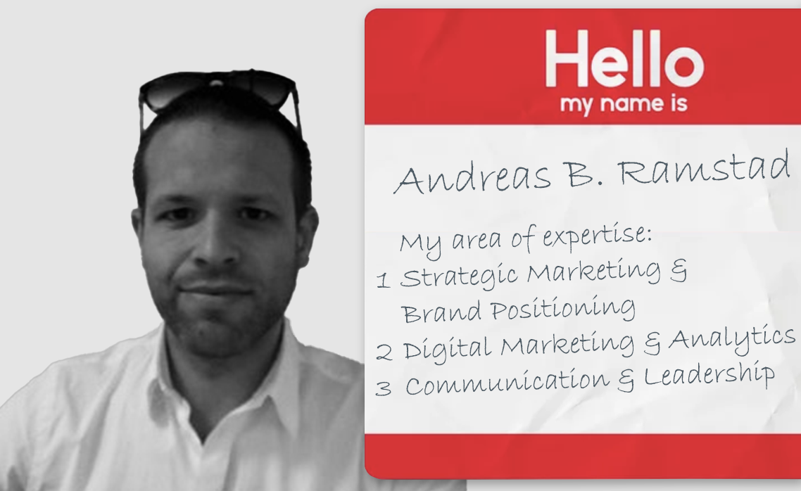 Black and white photo of a person wearing sunglasses on their head next to a red and white name tag that reads, "Hello my name is Andreas Ramstad Kristiansen."