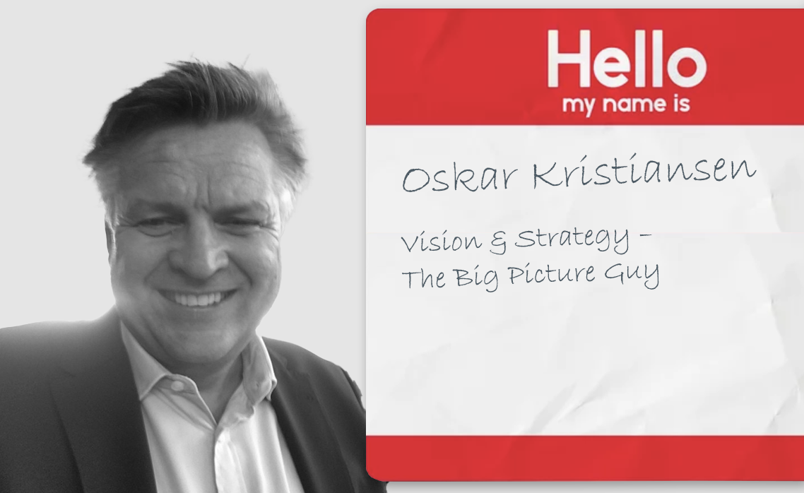 Black and white photo of a person smiling, wearing a suit and shirt, next to a red name tag with handwritten text "Oskar Kristiansen."