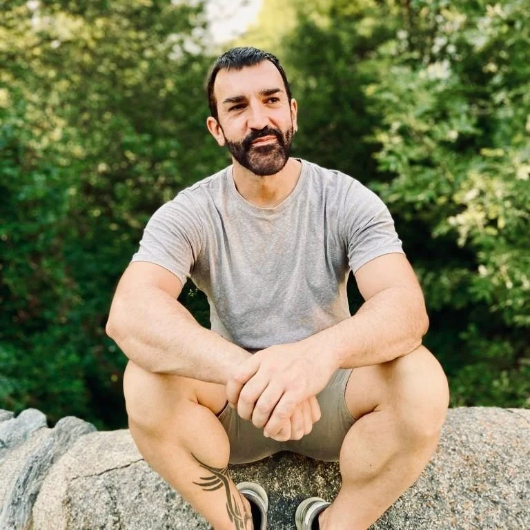 Jordi Panyella sentado sobre una roca, rodeado de naturaleza