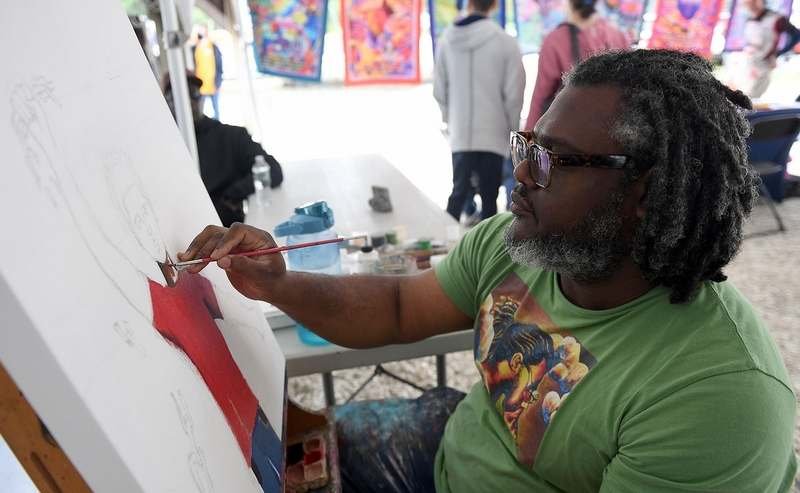  Andre Rochester, of Hartford, works on a live art piece during a Juneteenth Celebration at the Mystic Seaport Museum on Sunday, June 19, 2022. The piece depicts a young man with a shirt reading “Today I am Free' breaking chains. The museum partnered