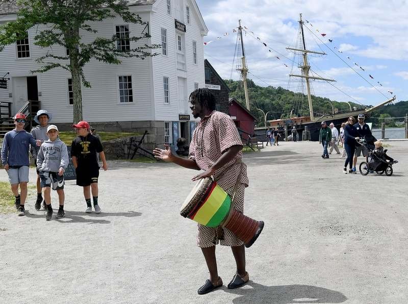  Seny Tatchol Camara, originally of Guinea and now a New Haven resident, walks through the Mystic Seaport Museum grounds playing a Djembe drum call before a Juneteenth Celebration on Sunday, June 19, 2022. The museum partnered with Discovering Amista