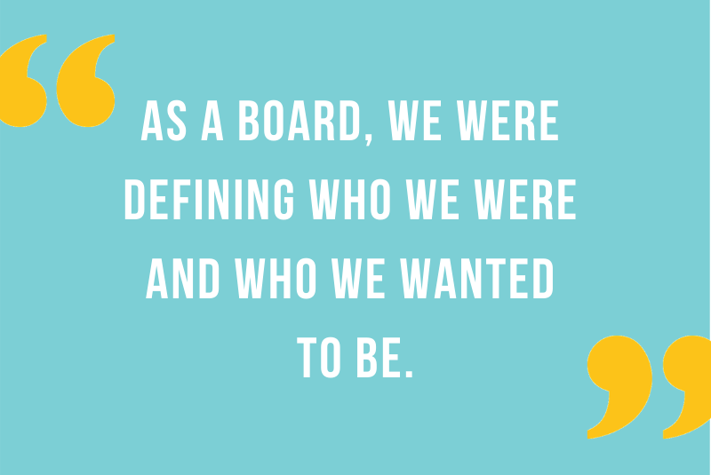 Happy smiling woman with curly hair lounging on couch.