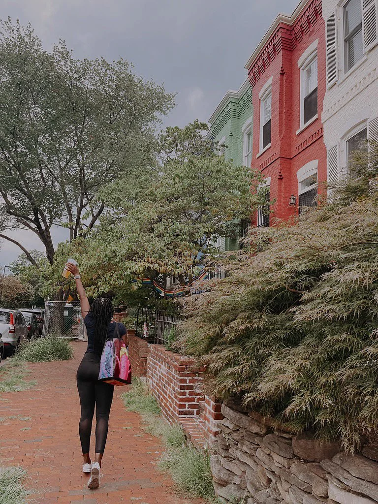 girl walking way with cup in hand