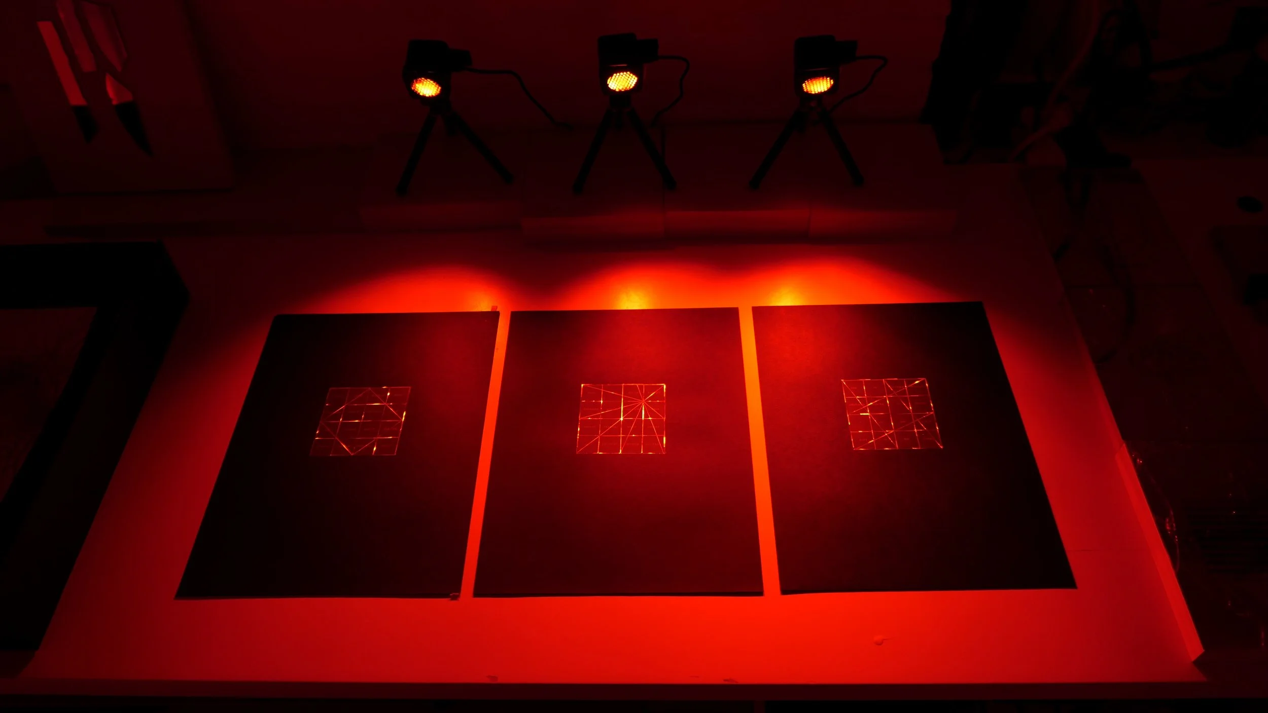 Magic Squares — installation: red light, reflective mylar, black strathmore paper, 11" x 14"h