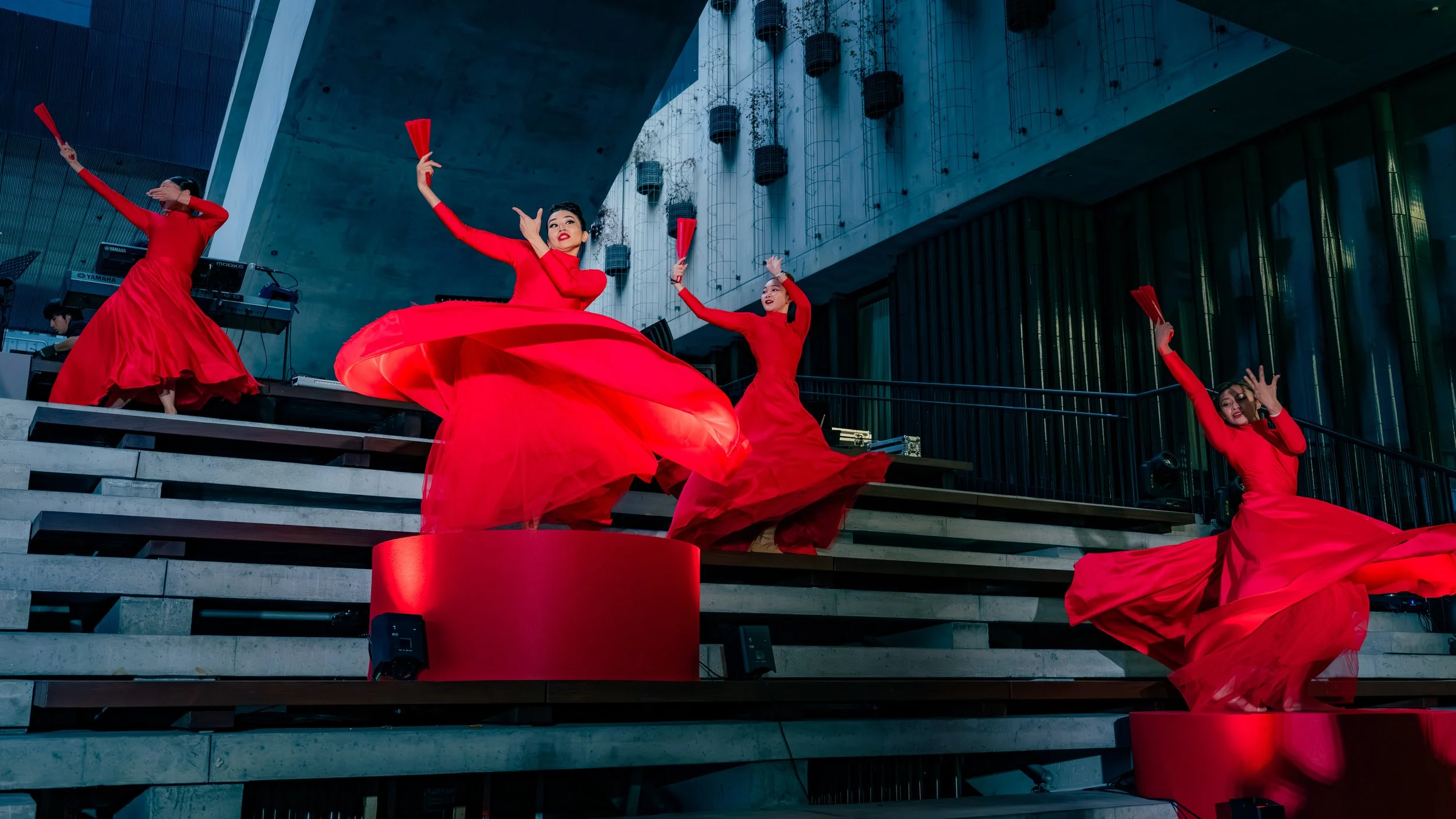 Contemporary dancers from BPM Productions Hong Kong perform a high-energy, modern routine on a red-carpeted staircase at the M+ Museum for the 2026 LIV Golf opening night.
