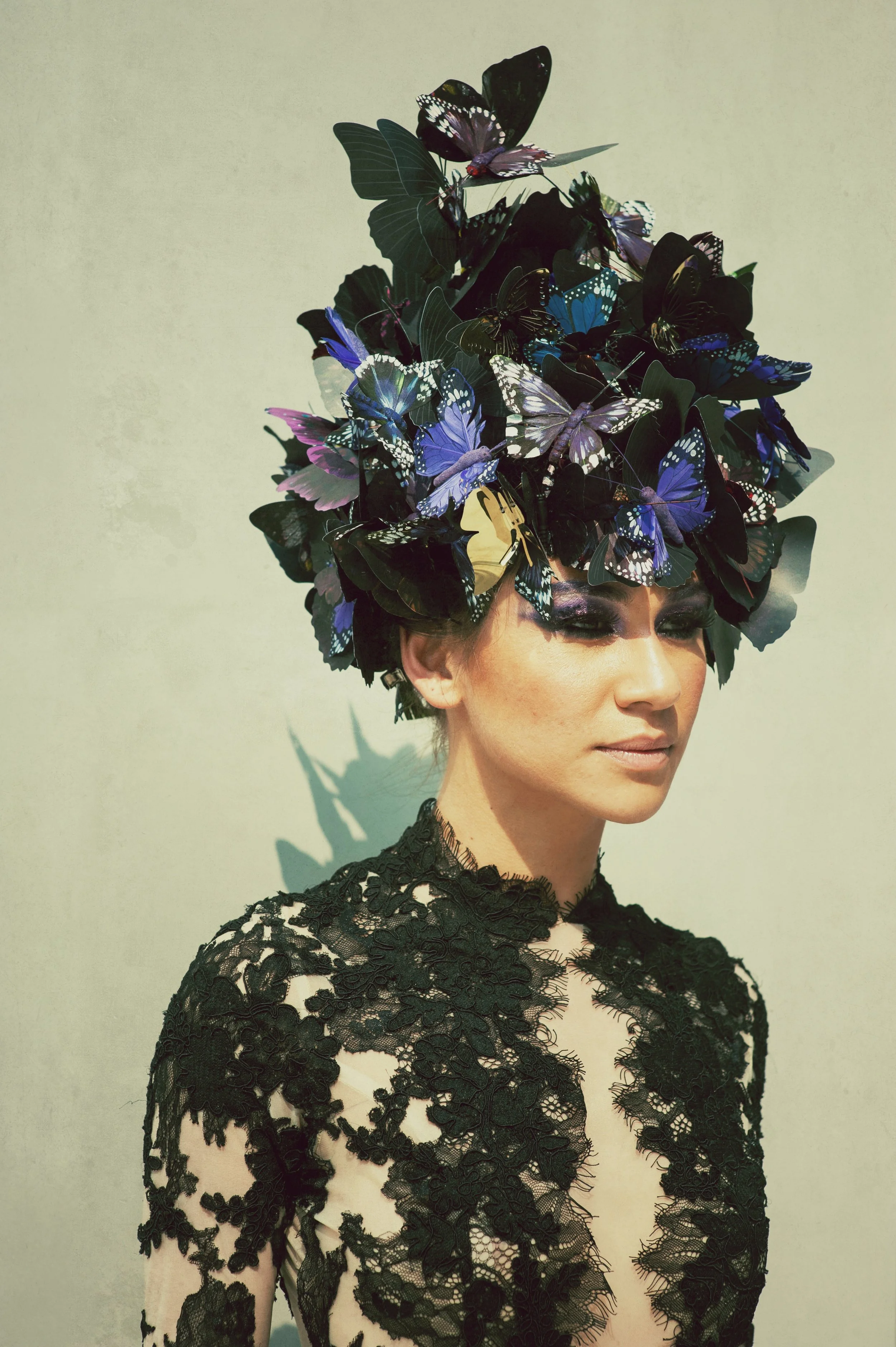 A close-up of a BPM Productions Hong Kong performer wearing an artistic butterfly-themed headpiece and black lace for a Clé de Peau Beauté brand activation.