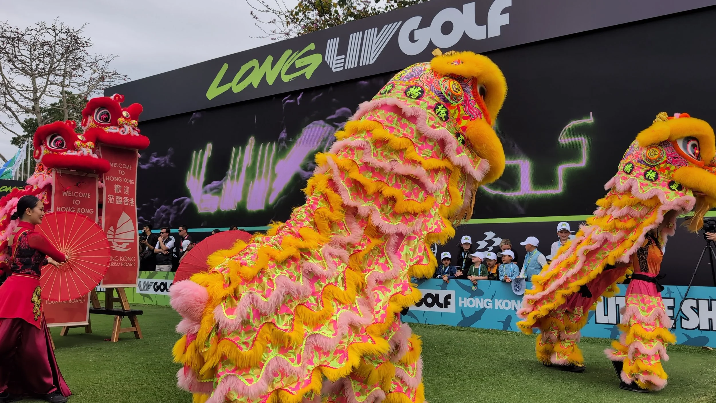 A colorful yellow and pink traditional lion dance performance managed by BPM Productions Hong Kong during the 2025 LIV Golf event at Fanling.