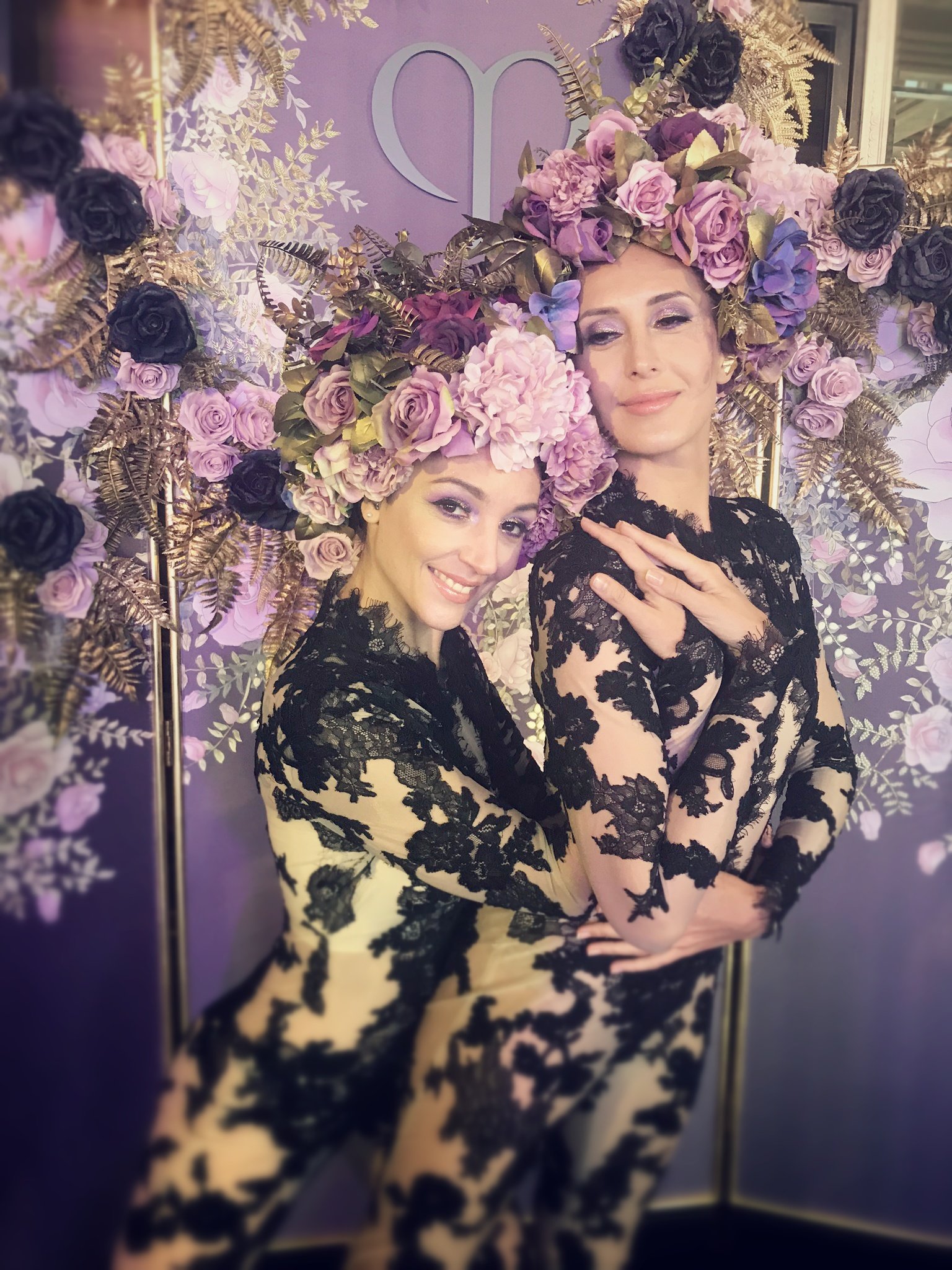 Two smiling performers from BPM Productions Hong Kong in high-fashion floral headpieces and lace during a luxury beauty event for Clé de Peau Beauté.