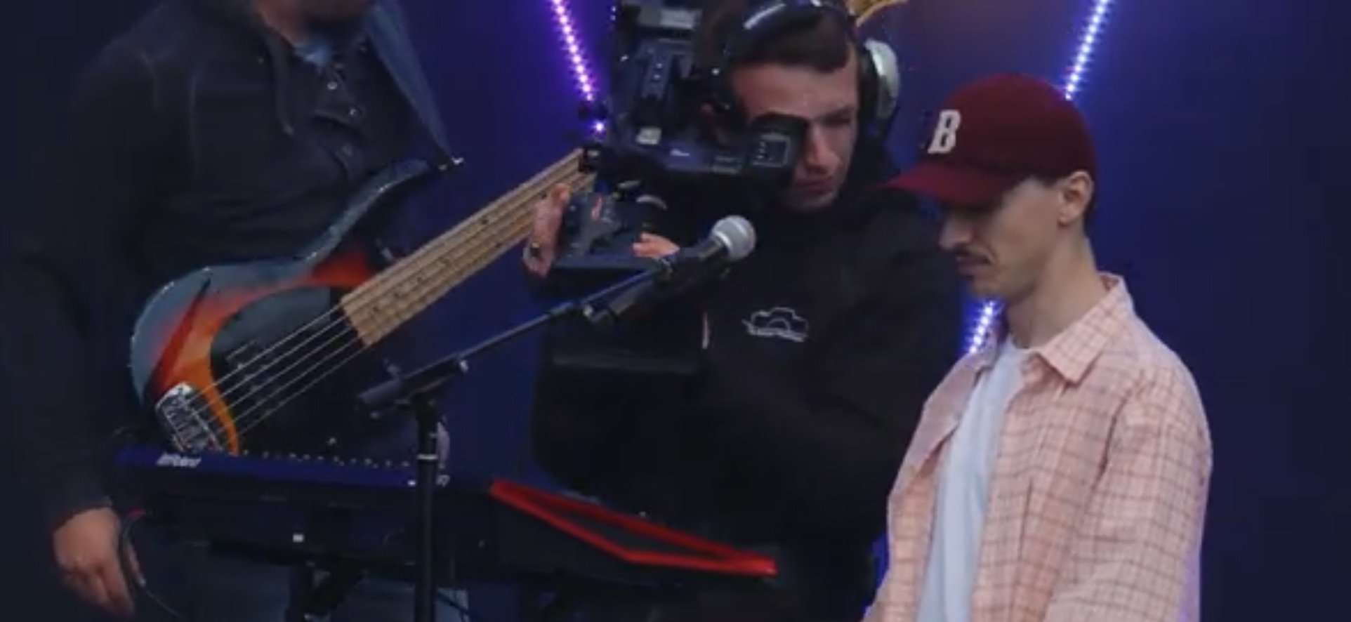 Muzikant met gitaar en cameraman tijdens optreden