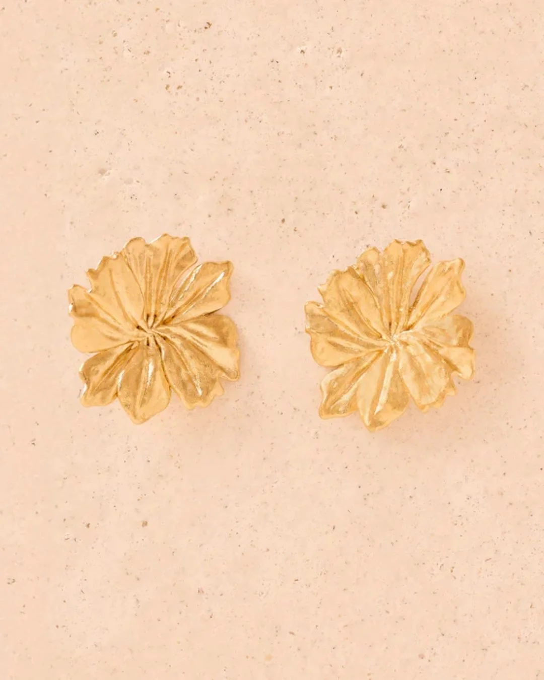 Boucles d’oreilles Adonis de la marque Agapée sur un fond rose
