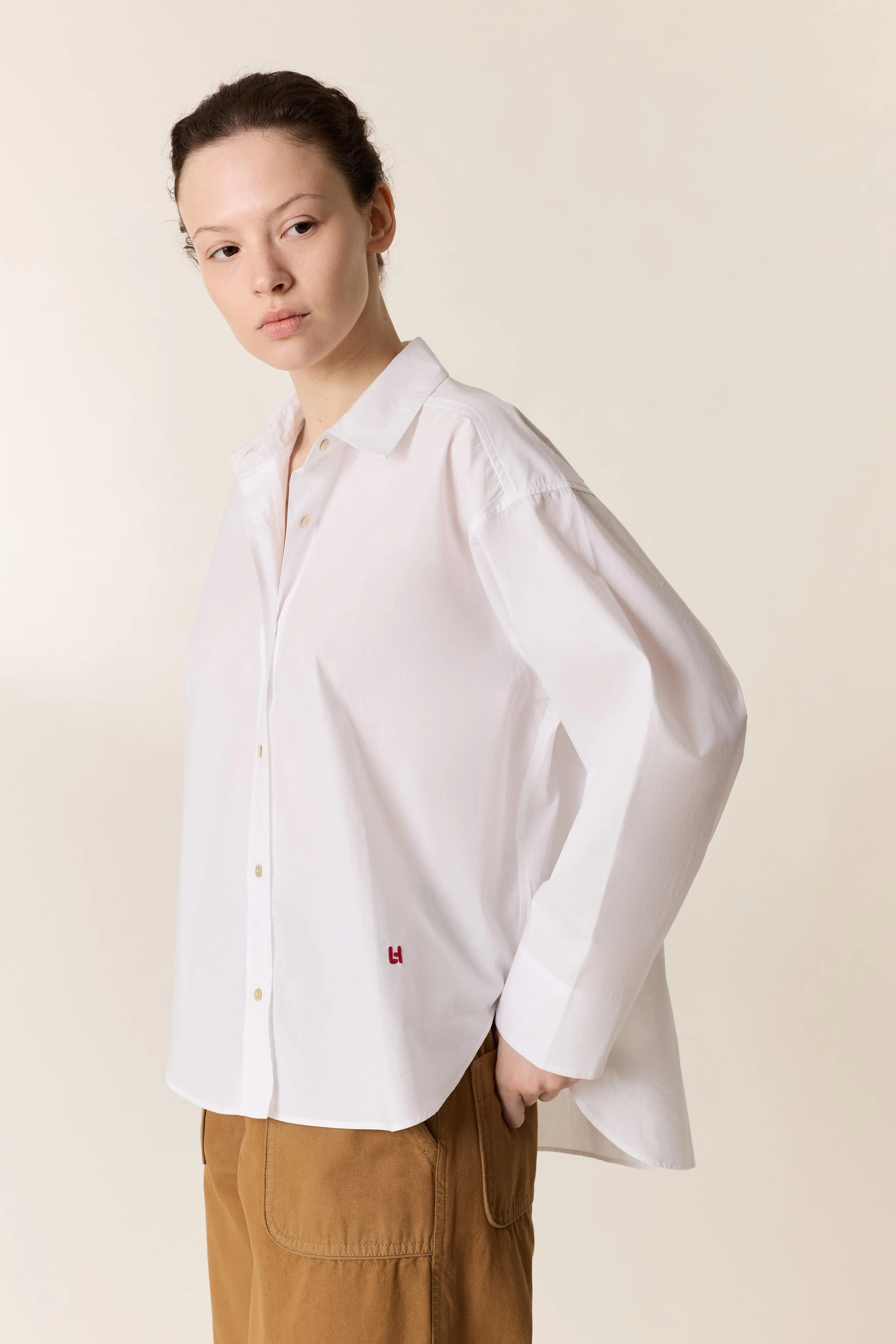 Détail de la boutonnière sur chemise blanche élégante.