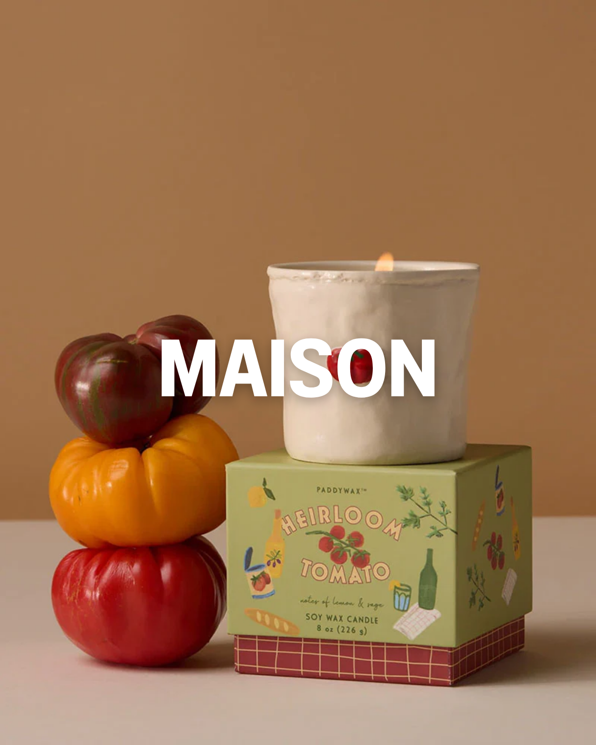 Bougies parfumées et tomates empilées, avec une boîte à souvenirs et un fond beige.