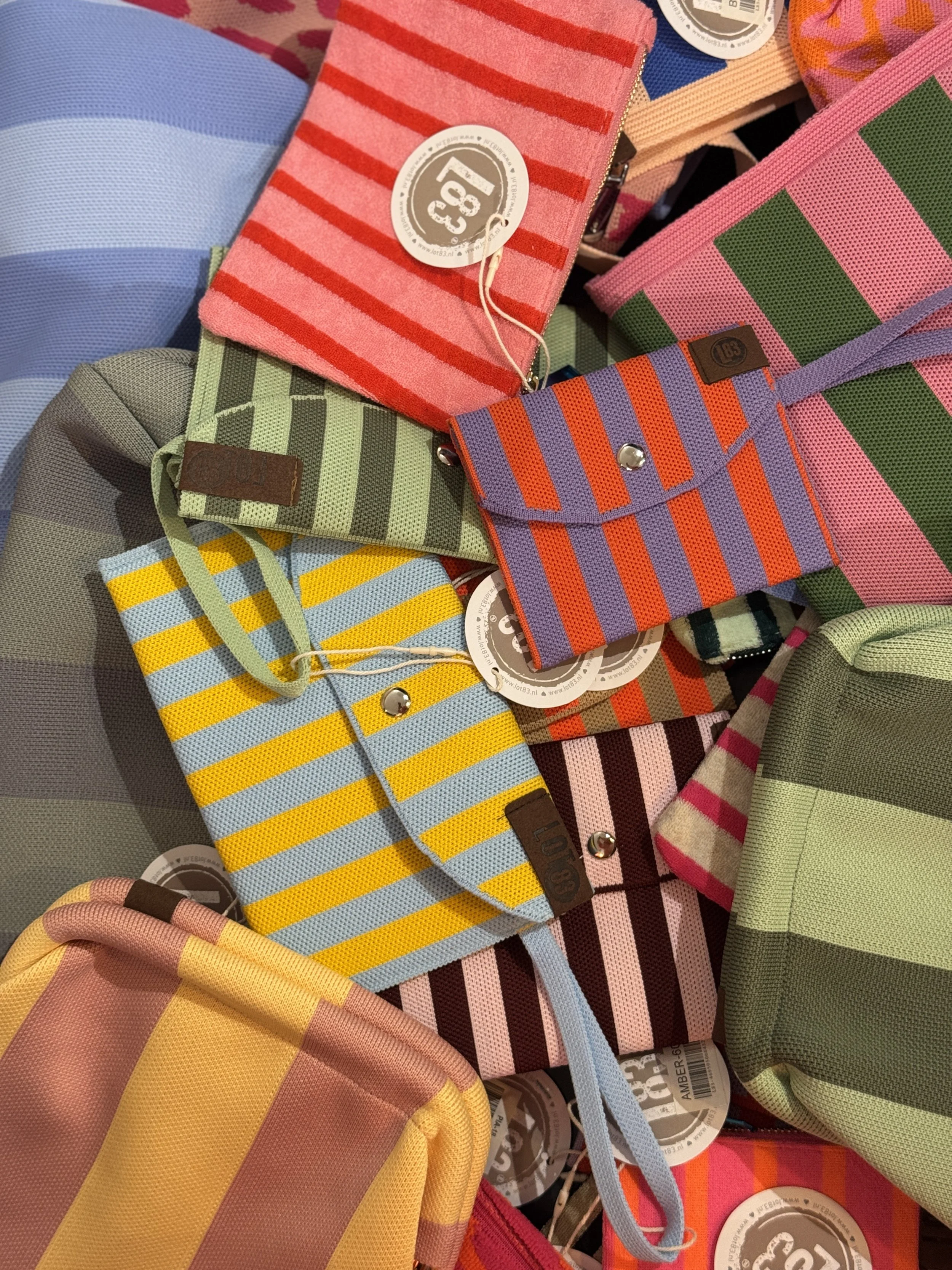 Décor intérieur avec une plante verte, une statue en forme de bust, un vase avec des pampas blancs, une assiette avec des bougies et un objet en forme de colonne vertébrale verte sur un meuble en bois.