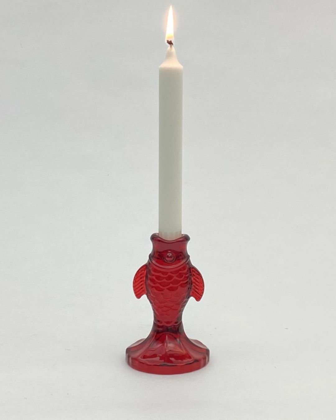 Bougeoir en verre rouge en forme de poisson stylisé, idéal pour une décoration lumineuse au style vintage et élégant
