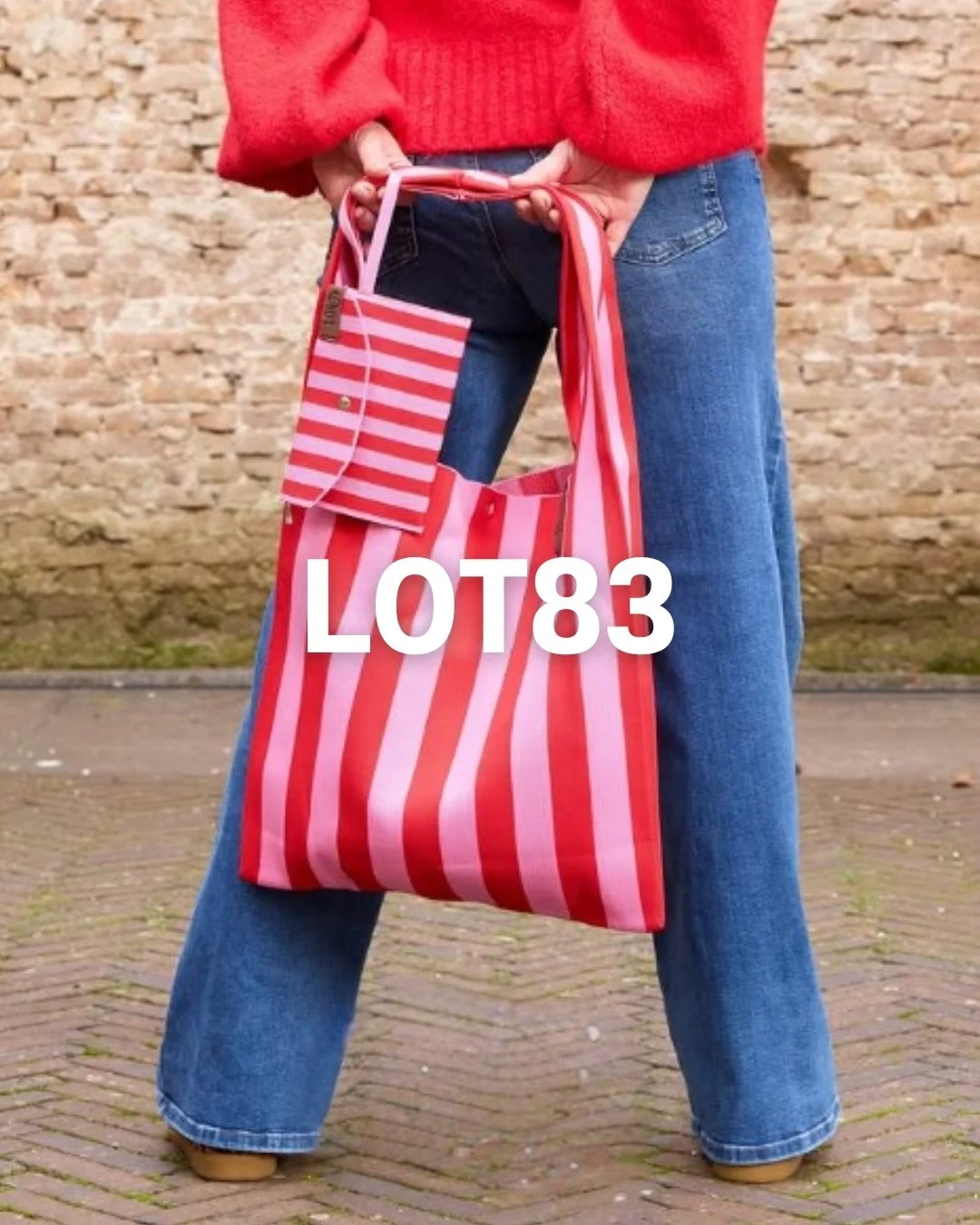 Modèle portant un sac rayé rouge et rose et un porte monnaie assortie