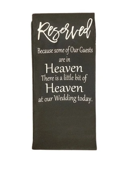Memorial chair covering banner with the phrase 'Because some of our guests are in Heaven, there is a little bit of Heaven at our Wedding today.' Elegant wedding day tribute decor