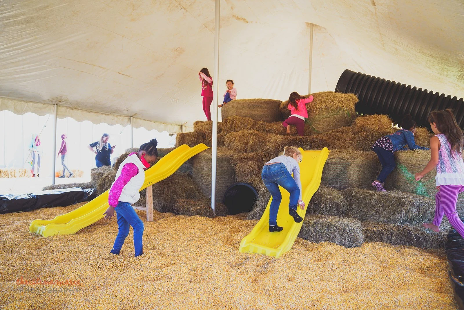 Children playing on a hay playground and farm with pumpkins