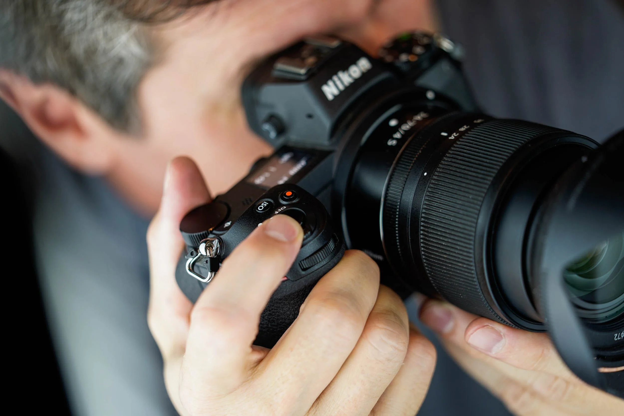 Paul Marnef, photographe utilisant un appareil photo Nikon avec grand zoom pour prendre une photo