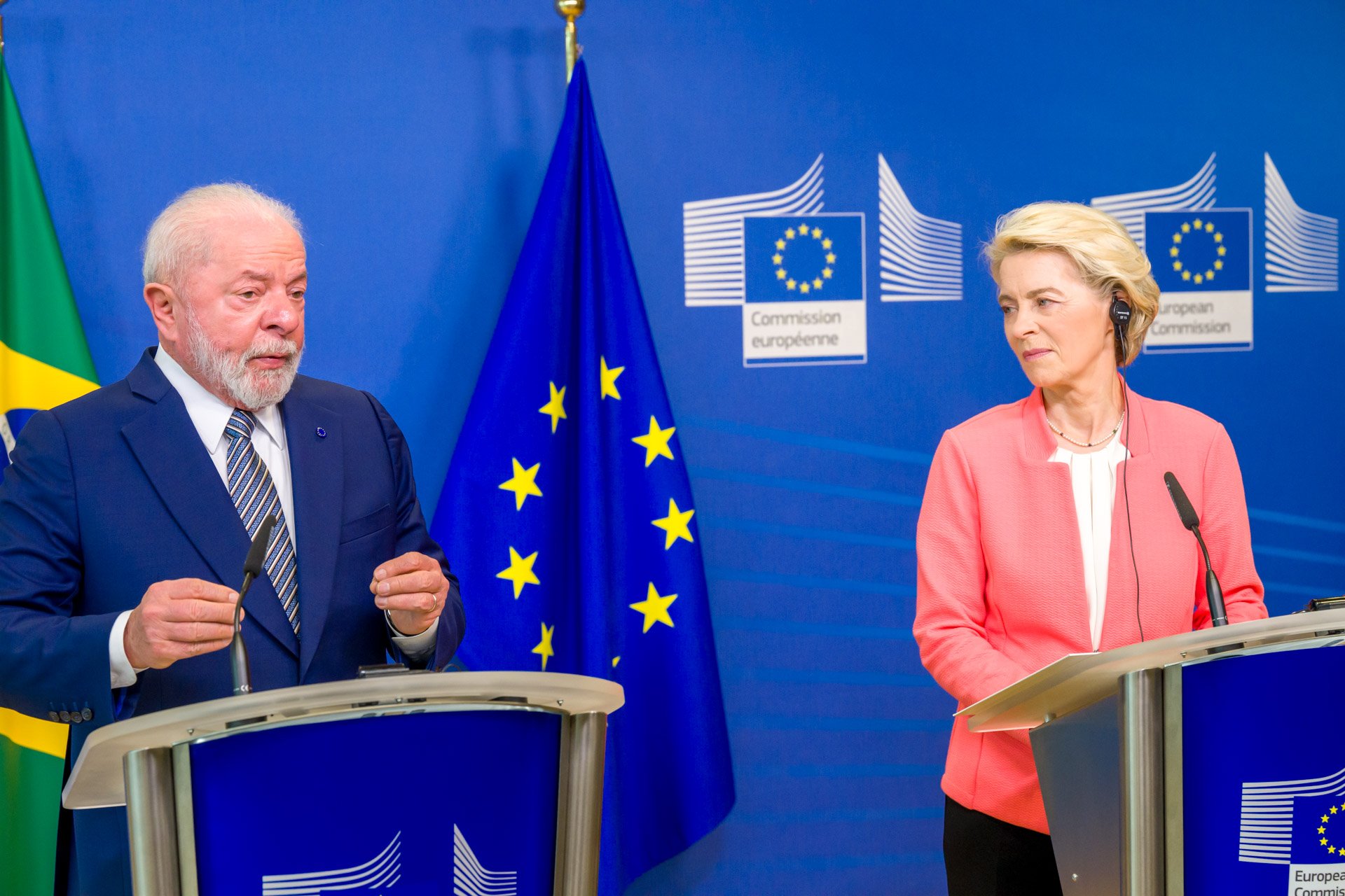 Deux personnes debout derrière des podiums devant des drapeaux de l'Union européenne et du Brésil, lors d'une conférence de presse.