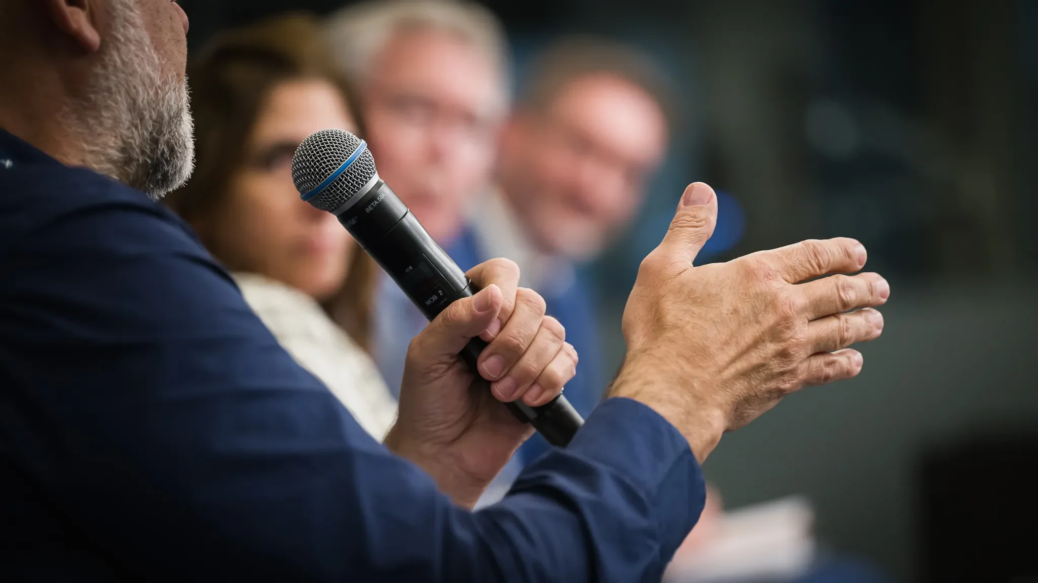 Photo symbolique d'un conérencier tenant un micro lors d'un événement au Résidence Palace à Bruxelles