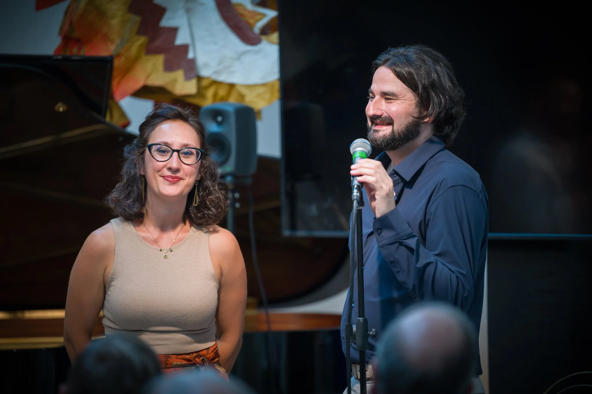 Un homme et une femme lors d'une performance ou d'une présentation en intérieur.